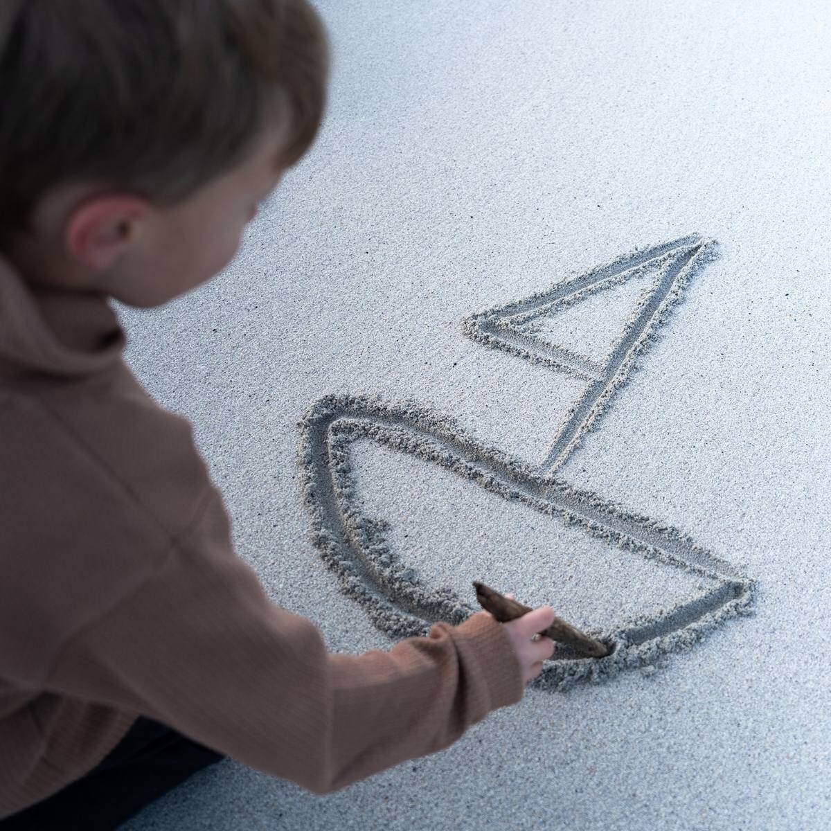 Boy drawing ship in sand_HAV Group_photo Elias Reite